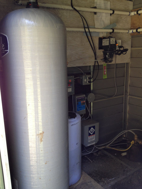 Chlorinator and contact tank followed by a whole house water filtration system removes iron and manganese from well water